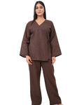 A woman wearing a chocolate brown linen co-ord set on a white background
