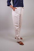 Person wearing beige linen pants by sabr india and a blue top 
